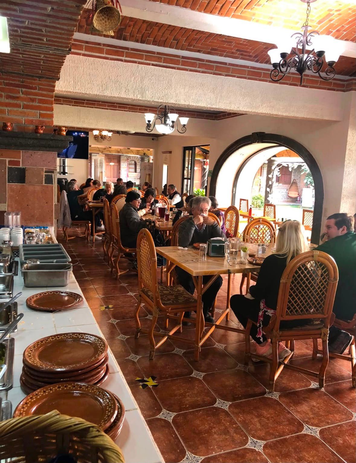 Comedor del restaurante con techos de ladrillo, arcos y candiles de herrería